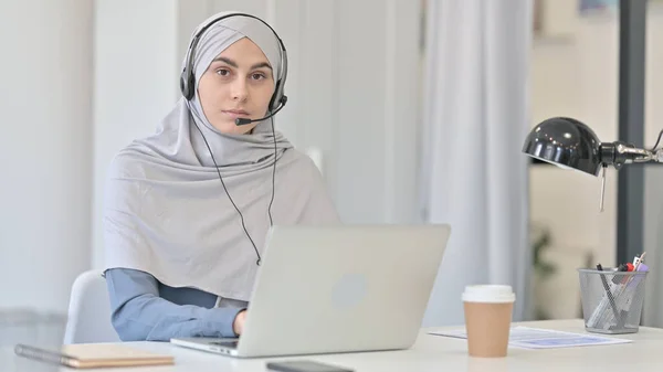 Mulher árabe jovem com fone de ouvido Olhando na câmera — Fotografia de Stock