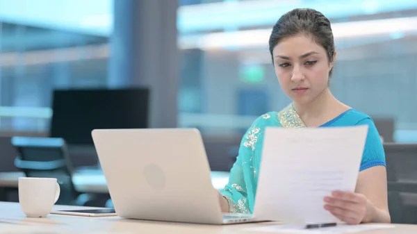 Indiase vrouw met laptop lezende documenten — Stockfoto