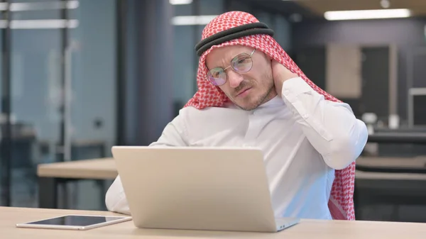 Medelålders arabisk man med bärbar dator med nacksmärta — Stockfoto