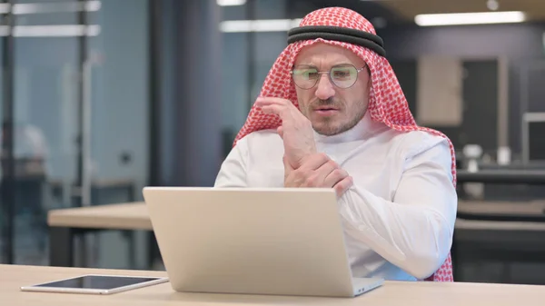 Medelålders arabisk man med bärbar dator med handledssmärta — Stockfoto