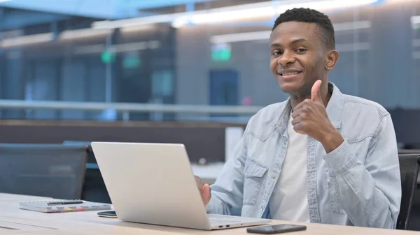 Tummen upp av afrikanska mannen med bärbar dator på jobbet — Stockfoto