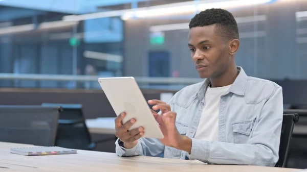 Приваблива африканська людина використовує планшет в офісі — стокове фото