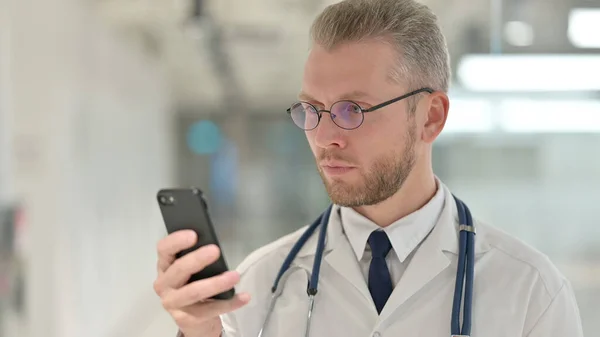 Portret młodego lekarza korzystającego ze smartfona — Zdjęcie stockowe