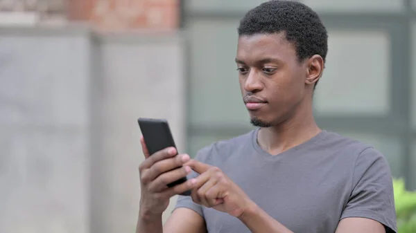 Akıllı telefon kullanan Pozitif Genç Afrikalı Adam Portresi 
