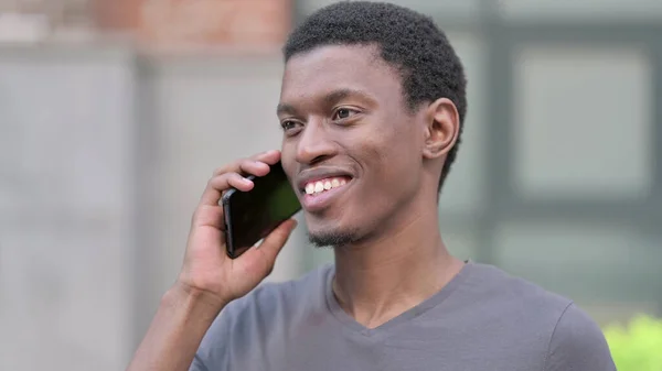 電話で話す陽気な若いアフリカ人の男の肖像 — ストック写真