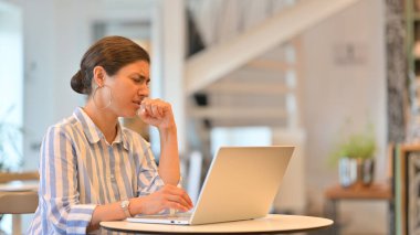 Kafede dizüstü bilgisayarlı hasta genç Hintli kadın öksürüyor. 