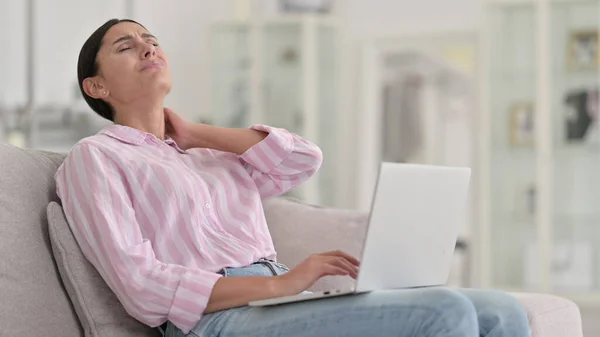 Стомлена молода латинська жінка з лапптопом, яка відчуває біль у домі — стокове фото
