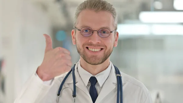 Portret pozytywny młody mężczyzna lekarz pokazując kciuki w górę znak — Zdjęcie stockowe