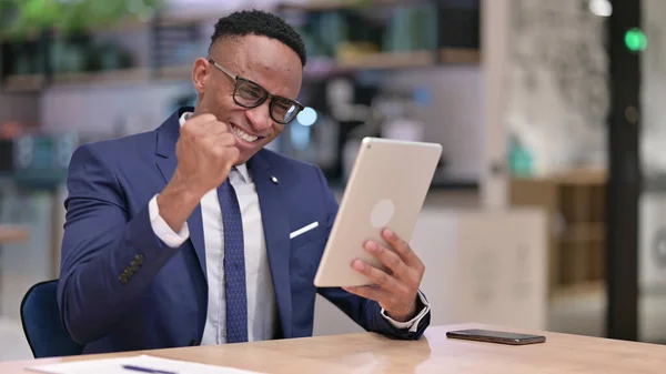 Spännande ung afrikansk affärsman firar framgång på Tablet in Office — Stockfoto