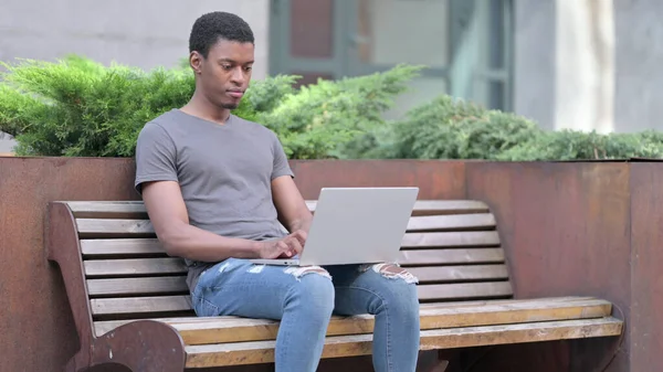 Jovem Africano Focalizado usando Laptop on Bench — Fotografia de Stock