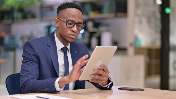 Ernsthafter afrikanischer Geschäftsmann mit Tablet im Büro — Stockfoto