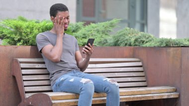Genç Afrikalı 'nın Bench' te akıllı telefondan kaybetmesine üzüldü. 