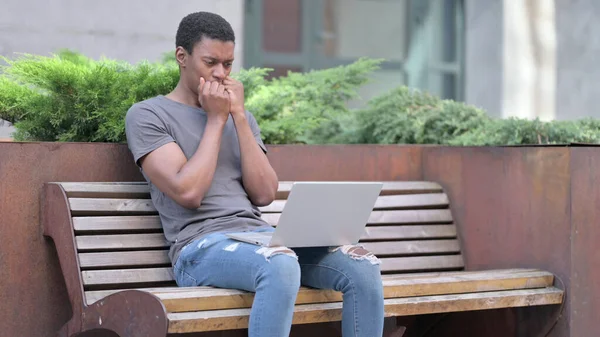 Jeune Africain bouleversé réagissant à la perte sur ordinateur portable sur le banc — Photo