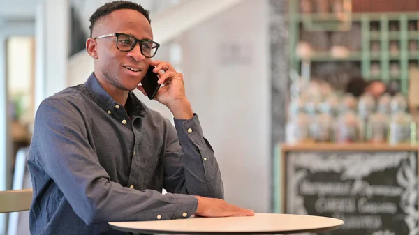 Alegre Africano Homem Falando em Smartphone no Café — Fotografia de Stock