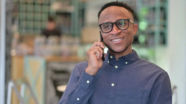 Porträtt av glad afrikansk man talar på smartphone — Stockfoto