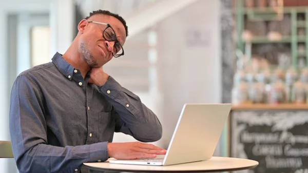Homme africain fatigué avec ordinateur portable ayant la douleur au cou dans le café — Photo