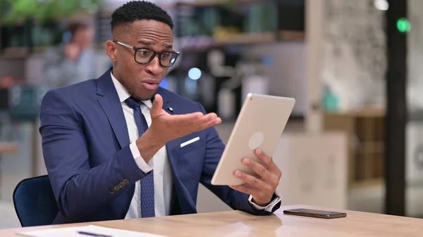 Besviken ung afrikansk affärsman som reagerar på förlust på Tablet in Office — Stockfoto