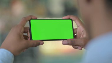 Afrikalı Adam Yeşil Krom Ekran ile Akıllı Telefondan İzliyor 
