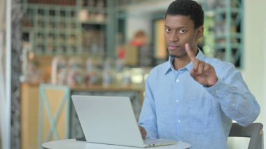 Dizüstü bilgisayarlı ciddi bir Afrikalı Parmak 'a hayır diyor. 