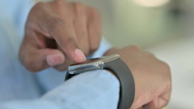 Smartwatch kullanarak Ciddi Genç Afrikalı Adam 'a yaklaş 