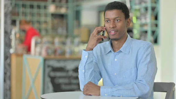 Afrikansk man pratar på smartphone i Café — Stockfoto