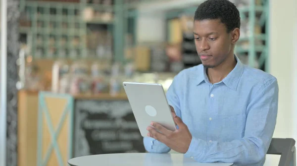 在咖啡店使用平板电脑的专业非洲青年男子 — 图库照片