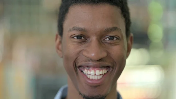 Primer plano del joven africano feliz mirando a la cámara — Foto de Stock