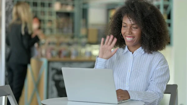 Junge Afrikanerin macht Videoanruf auf Laptop im Café — Stockfoto