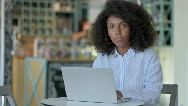 Jovem mulher africana com laptop Olhando para a câmera no café — Fotografia de Stock