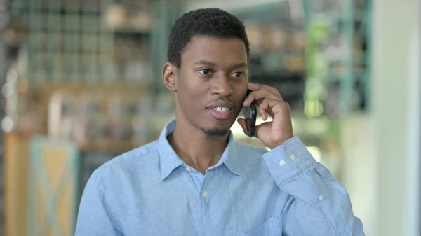 Porträtt av glad ung afrikansk man talar på smartphone — Stockfoto