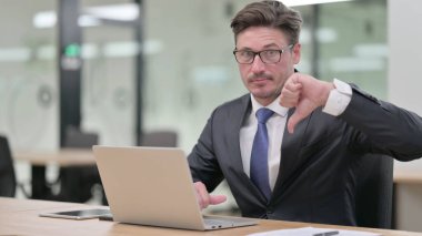 Ofisinde dizüstü bilgisayarı olan Ciddi Orta Çağ İşadamından Başparmak İndirme 