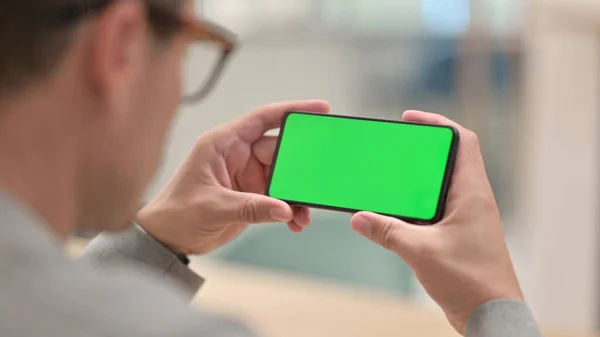 Středověký muž při pohledu na Smartphone se zelenou chroma obrazovkou — Stock fotografie