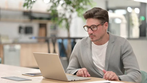 Medelålders man lämnar laptop och går iväg — Stockfoto