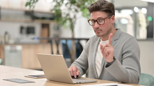 Hombre de mediana edad con el ordenador portátil que muestra ningún signo con dedo — Foto de Stock