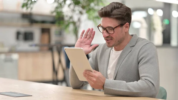 Moyen Age Homme faisant chat vidéo sur tablette à la maison — Photo