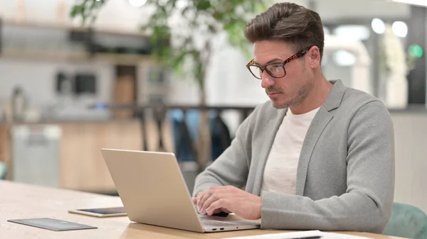 Sérieux homme du Moyen Âge en utilisant un ordinateur portable — Photo