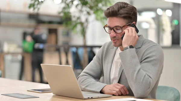 Středověký muž s notebookem mluví na telefonu — Stock fotografie