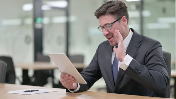 Professionnel Moyen Age Homme d'affaires faisant Video Chat sur tablette dans le bureau — Photo