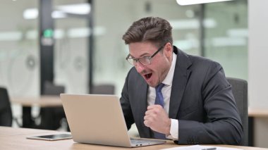 Ofisteki Dizüstü bilgisayarda Başarı Kutlaması Heyecanlı Orta Çağ İşadamı 