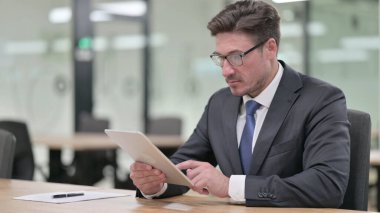 Ofiste Tablet kullanan Ciddi Profesyonel Orta Çağ İşadamı 