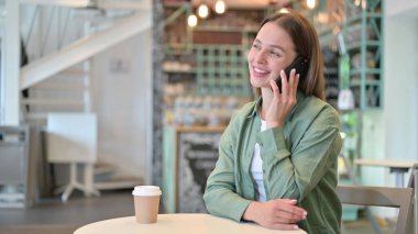 Cafe 'de Neşeli Genç Kadın Telefonda Konuşuyor 