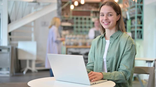 Laptoplu Kadın Kafede Kameraya Gülümsüyor — Stok fotoğraf