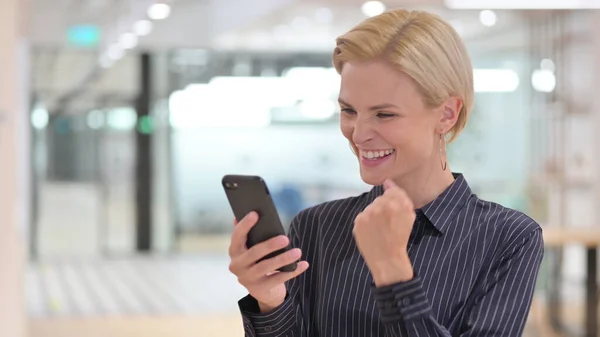 《兴奋的女商人在智能手机上庆祝成功的画像》 — 图库照片