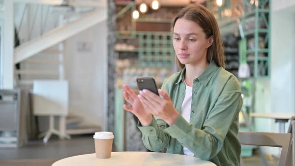 Mujer joven seria usando Smartphone en Café —  Fotos de Stock