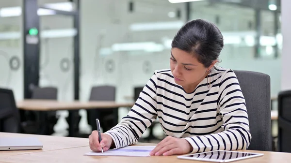 Serious Indian Woman Writing on Paper, Paperwork Stock Photo