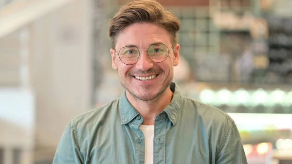 Kameraya bakan gülümseyen orta yaşlı adamın portresi 