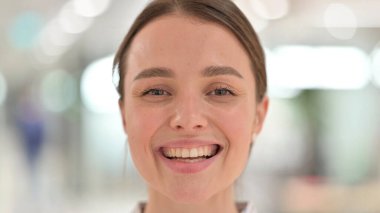 Kameraya gülümseyen genç kadının yüzüne yakından bakın.