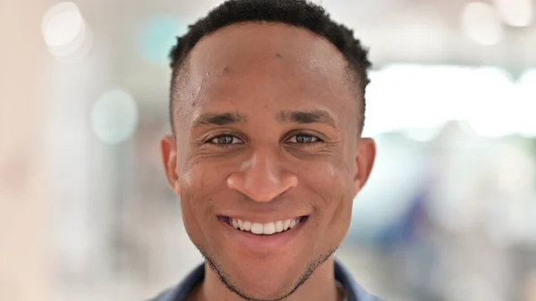 Close-up do rosto do homem africano casual sentindo-se sorrindo para a câmera — Fotografia de Stock