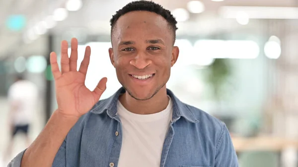 Retrato do homem africano alegre e casual acenando para a câmera — Fotografia de Stock