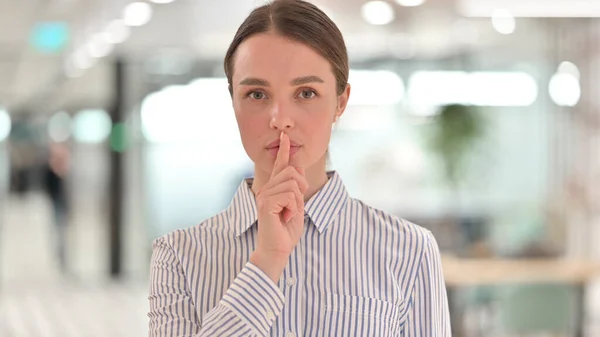 Portret van jonge vrouw zetten vinger op lippen, Stil gebaar — Stockfoto